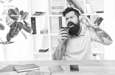 Mutlu adam yemek fincanı için şarkı söylüyor ofiste kulaklıkla şarkı dinliyor, müzik dinliyor..