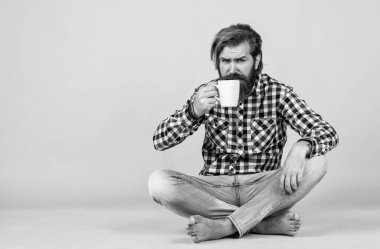 Bardakla içecek. Çay ya da kahve içmek. Günaydın. Evde sabah havası var. İlham konsepti. Hipster adam kahve içer. Beyaz bardak tutan yakışıklı sakallı adam. Boşluğu kopyala.
