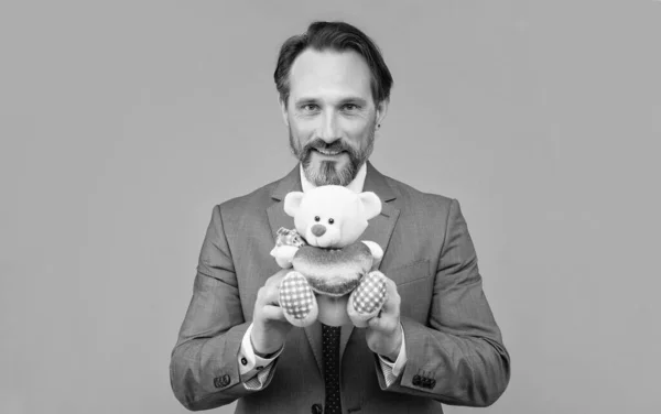 Szczęśliwy Senior Mężczyzna Garniturze Trzymać Zabawka Niedźwiedź Szarym Tle Urodziny — Zdjęcie stockowe