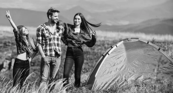 Summer relax. mountain tourism camp. hiking outdoor adventure. group of people spend free time together. man and two girls pitch tent. wanderlust discovery. friends camping. reach destination place.