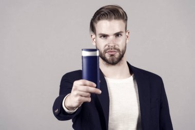 Şampuan veya jel şişe el ile iş adamı. Şık saç veya saç kesimi olan sakallı adam. Spa banyo veya duş için kozmetik. Saç Bakımı ve sakal damat. Mens güzellik ve sağlık.