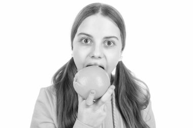 Neşeli çocuk turunçgil portakal meyvesi yiyor. Beyazın üzerinde izole edilmiş vitaminler yiyor..