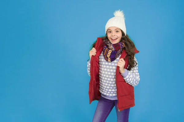 winter kid fashion sales, copy space. child with long curly hair in knitted hat. cold season style christmas activity. childhood happiness. thermal clothing. happy teen girl wear warm clothes.