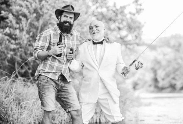 Men relaxing nature background. Fun and relax. Weekend time. Fishing skills. Set up rod with hook line and sinker. Fishing and drinking beer. Bearded man and elegant businessman fishing together.