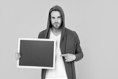 Adam sarı arka planda fotokopi alanı reklamı sunuyor..