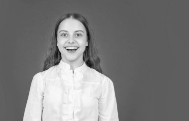 Beyaz gömlekli şaşkın çocuk kırmızı arka planda olumlu duygularını ifade ediyor, kopyalama alanı, şaşkınlık.