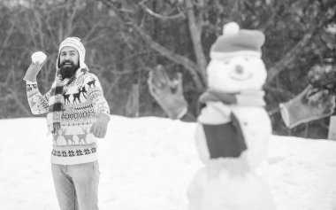 Temiz hava iyi gelir. Kardan adam ve neşeli sakallı hippi örgü şapka ve sıcak eldivenler dışarıda karla oynuyor. Kış gününde iyi eğlenceler. Kar yağsın. Noel tatili. Aktif yaşam tarzı. Kar oyunları.