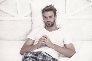 Güne başlıyorum. Adam yatak odasında televizyon izliyor. Tembel pazar hafta sonu evde. Sabah programını izle. Adam televizyon izliyor. Yatakta uzaktan kumandayla kanal değiştir. Uzaktan kumandalı pijamalı yakışıklı adam..