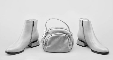 Sarı arka planda ayak bileği çizmeleri. Ayakkabı dükkanı. Alışveriş konsepti. Kadın derisi şık ayakkabılar. Moda aksesuarı. Bir çift şık deri ayakkabı ve çanta. bej çizmeler.