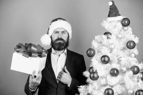 Christmas greetings. Best gifts shop. Christmas gifts and decorations. Secret Santa concept. Buy present. Man bearded hipster formal suit near christmas tree. Office christmas party. Winter holidays.