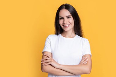 Normal gömlekli mutlu kadın, sarı arka planda izole edilmiş, fotokopi odası olan. Stüdyoda sıradan bir kadın. Sıradan bir kadının portresi. Sıradan giyinen bir kadının fotoğrafı..