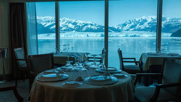 Empty restaurant seating interior with panoramic windows at scenic glacier bay nature. Mountain glacier restaurant in natural park. Hubbard Glacier restaurant. Travel destination, no people.
