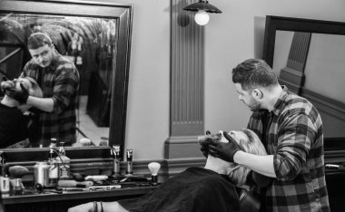 Saç kesimi bir sanattır. Bıyık ve sakal. Kuaförde sandalyeye otur. Kuaförde olgun bir adam. Saç bakımı ve erkek bakım konsepti. Formunu koru. Sakallı adam berbere sakal tıraşı oluyor..