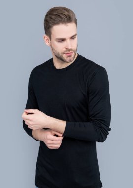 Kirli sakalı olan beyaz bir adam. Tüylü ve sakallı. Stüdyoda sakallı bir adam. Gri arka planda sakallı bir adam var..