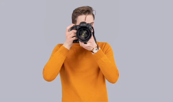man photographer taking picture with camera isolated on grey background. man photographer with camera in studio. man photographer with photo camera. photo of man photographer with camera.