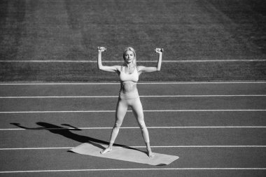 Spor salonundaki atletik kadın stadyumdaki halterlerle antrenman yapıyor..