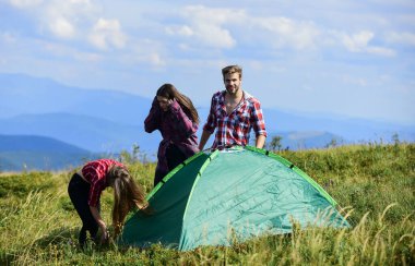 Bir grup insan birlikte boş zaman geçirir. Arkadaşlar kamp yapıyor. Doğa yürüyüşü macerası. Adam ve iki kız çadır kuruyor. Seyahat tutkusu keşfi. Hedefe ulaş. dağ turizm kampı.