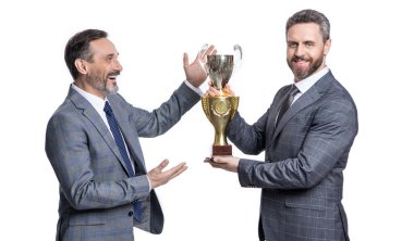 Gülümseyen iş adamları beyaz arka planda izole edilmiş ödülü kutluyorlar. İş adamları ödülü stüdyoda kutluyor. İş adamları ödülü kutluyor. İş adamlarının fotoğrafı şampiyonluk kupası ile ödülü kutluyor.