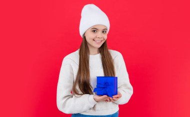 Noel tatili. Stüdyoda Xmas 'lı genç bir kız var. Genç kız Xmas mevcut kırmızı arka planda izole.