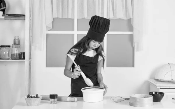 kid cooking in kitchen. choosing future career. ready to eat. healthy and organic food only. professional menu. teen girl chef wearing uniform. child study how to cook by recipe. Do not hurry up.