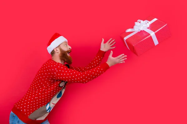 带着圣诞礼盒的快乐男人 快乐的圣诞节 桑塔的人赶着用红色隔离的圣诞礼盒 — 图库照片