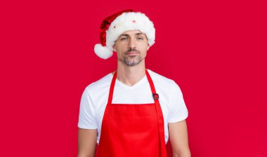 Kırmızı barmen önlüklü ve Noel Baba şapkalı gerçek bir olgun adam..