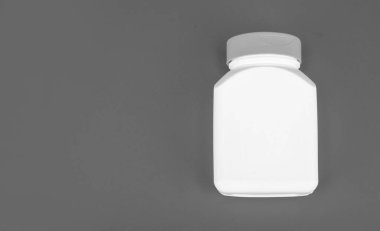 Mavi arkaplanda vitamin ve fotokopi alanı olan hap kavanozu beyaz rengi.