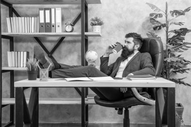 Yorgun müdür dinlenir ofiste çay ya da kahve içerek, mola verir..