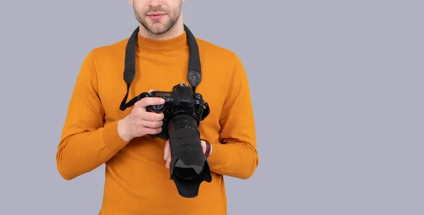 cropped view of man photographing with camera in studio. man photographing with photo camera. photo of man photographing with camera. man photographing with camera isolated on grey background.