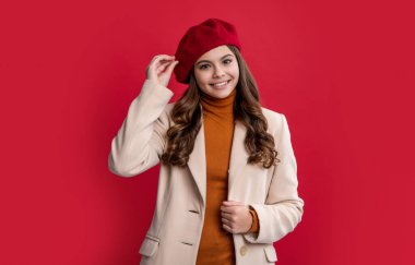 Kırmızı arka planda izole edilmiş Paris 'li genç kız. Stüdyodaki Paris 'li genç kız. Genç Paris 'li genç kız. Paris 'li esmer bir genç kızın fotoğrafı..