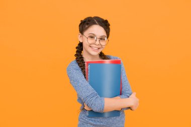 Kütüphane yaratıcılığı geliştirmeye odaklandı. Mutlu kız kütüphane kitaplarını tutuyor. Yürüyen ansiklopedi. Okul kütüphanesi. Bilgi ve bilgi. Bibliopol. Kitapçı. Çocukluk hayal gücü kütüphanesi.