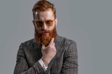 Smokinli resmi adam stüdyoda gözlük takıyor. Smokinli resmi bir adam. Smokin giymiş sakallı bir adamın resmi. Smokinli resmi adam Griler 'de izole edilmiş.