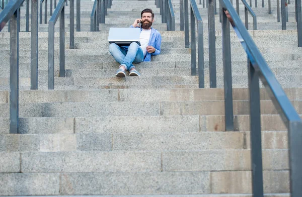 Adamın dizüstü bilgisayarında video bağlantısı var, kopyalama alanı. Adamın dışarıda online video iletişimi var. Adamın dışarıda çevrimiçi video bağlantısı var. Adamın merdivenlerde online video bağlantısı var..