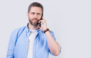 Adamın iletişim çağrısı, reklam. İletişim kuran bir adamın fotoğrafı. Adamın telefon görüşmesi var. Stüdyoda izole edilmiş. Stüdyodaki iletişimli adam..