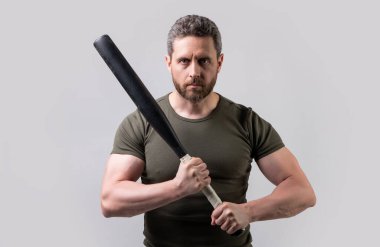 Yarasalı öfkeli holigan adam gri arka planda izole edilmiş. Stüdyoda sopalı holigan adam. Sopalı holigan adamın fotoğrafı. Yarasayla tehdit eden holigan adam..