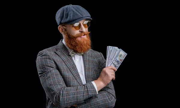 photo of cheerful rich retro man with money wear peaked cap. rich retro man with money isolated on black. rich retro man with money in studio. rich retro man with money on background.