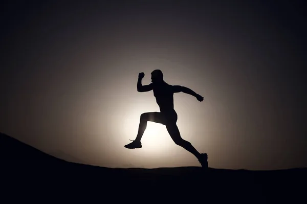 silhouette or man runner, guy running outdoor on clear sky background, copy space