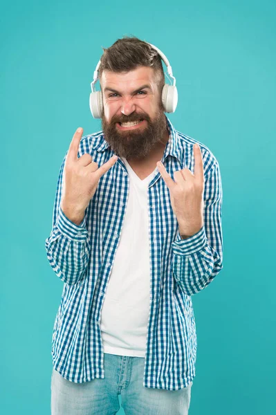 Heavy metal and hard rock. Streaming music sites. Wireless technology. Hipster with beard listening music. Handsome music lover. Man in headphones. User friendly interface and large library of tunes.
