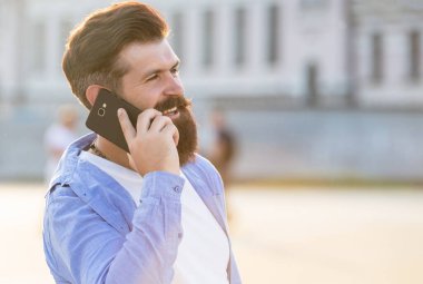 Adam açık havada akıllı telefondan konuşur, uzayı taklit eder. Adam dışarıda akıllı telefondan konuşuyor. Adam sokakta akıllı telefondan konuşuyor. Akıllı telefondan konuşan adamın fotoğrafı..