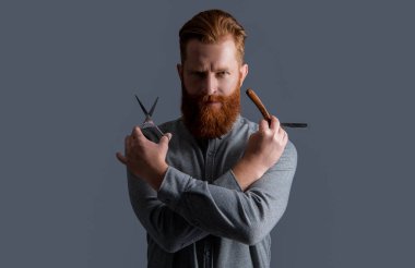 Berber adam gri arka planda izole edilmiş. Berber dükkanında elinde makas olan bir adam. Berber dükkanındaki berber. Berber adam kuaförde makas ve bıçak tutuyor. Berber dükkanı konsepti.