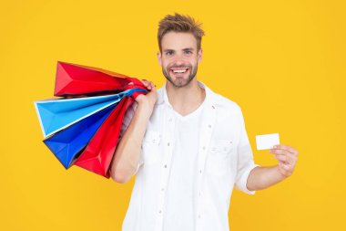 Satıştaki adam sarı kart ile izole edilmiş. Stüdyoda alışveriş yapan adam. Arka planda alışveriş yapan adam. Alışveriş merkezindeki adamın fotoğrafı..