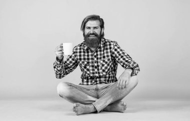 Mutlu sakallı adam sabah kahvesini içiyor. Adam fincandan sıcak çay içiyor. Sana da günaydın. Enerjik, sıcak bir içecek. İlham için biraz kahveye ihtiyacım var. Güne mükemmel bir başlangıç.