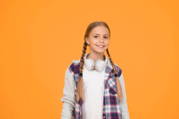 Streaming services. Happy little girl wearing modern headphones. Enjoy track. Wireless means freedom. Headphones with wireless technology. Small child listening to music modern wireless earphones.