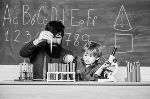 Laboratory test tubes and flasks with colored liquids father and son child at school. laboratory research and development. Chemistry beaker experiment. bearded man teacher with little boy. Imagine.