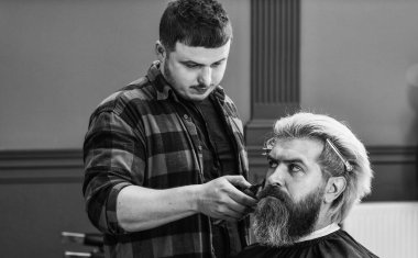 Sakallı ve bıyıklı olgun bir hippi berber dükkanında saçına bakar, berber..