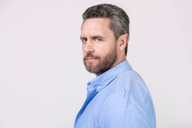 Gri arka planda sakallı ve fotokopi alanı olan olgun bir adamın yüzü. Stüdyoda sakallı, olgun bir adam. Sakallı, olgun bir adamın fotoğrafı. Kirli sakallı, normal gömlekli olgun bir adam..