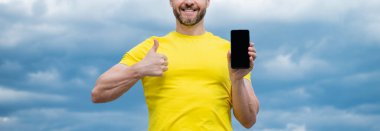 Kopya alanı olan akıllı telefonun reklamını yapan adamın kırpılmış görüntüsü.