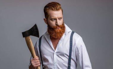 Geçmişinde balta olan Kafkasyalı vahşi bir adam. Elinde baltası olan vahşi bir adamın fotoğrafı. Gri üzerinde baltalı vahşi bir adam. Stüdyoda baltası olan vahşi bir adam..