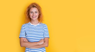 Sarı arka planda izole edilmiş mutlu kızıl saçlı kız portresi. Stüdyodaki genç kızıl saçlı kızın uzay portresini kopyala. Yetişkin kızıl kız portresi.