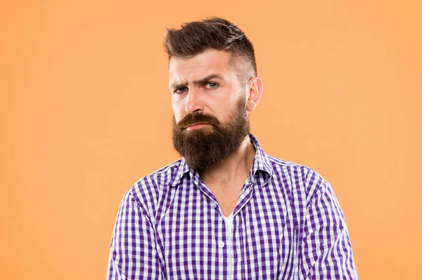 Beware of the facial hair. Serious hipster with long beard and stylish hair on yellow background. Brutal guy with shaped beard and mustache hair. Bearded man with unshaven face hair.
